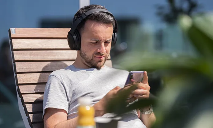 Kille med smartphone på Axfoods takterrass